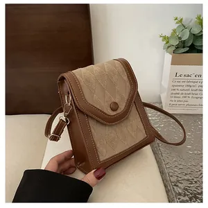 Detail of vintage beige quilted crossbody bag with brown PU leather trim and metal buckle