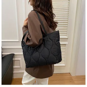 Close-up of black quilted tote bag with gourd stitching and comfortable shoulder strap