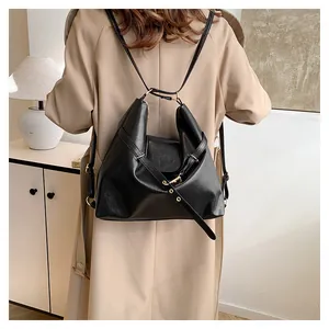 Close-up of black leather backpack with flap and adjustable straps on khaki trench coat