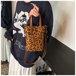 Chic leopard print crossbody bag with leather straps and knotted detail in macro view