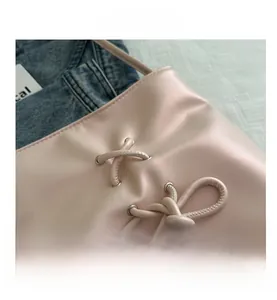 Détail d'un sac seau rose avec un nœud papillon doux et des œillets argentés lacés