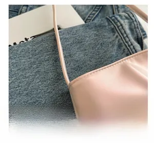 Gros plan sur un sac seau rose avec des détails plissés et une texture en cuir lisse