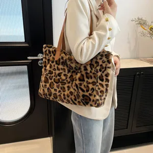 Borsa tote leopardata in ecopelliccia con spalline in pelle indossata da modella