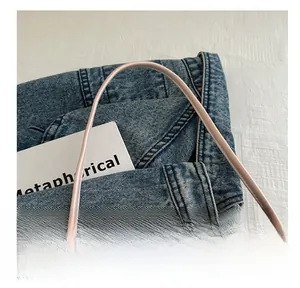 Détail de la poignée du sac seau en cuir rose avec texture douce et design fin délicat