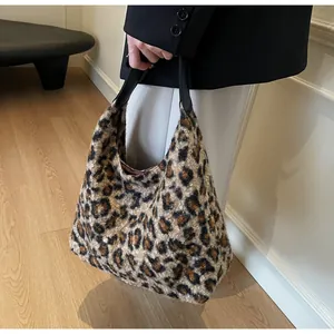 Detail der Plüschhandtasche mit Leopardenmuster, Kunstfell-Textur und schwarzem Ledergriff
