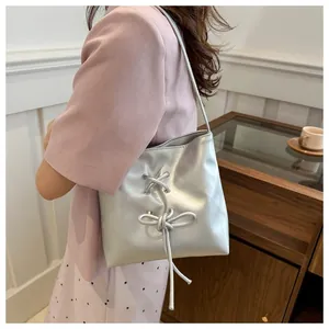 Sac à bandoulière argenté avec détail de nœud présenté dans un cadre chic et moderne