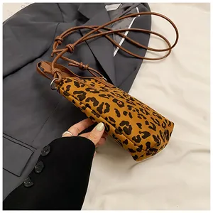 Detail of leopard print crossbody phone bag with knot strap on a grey blazer