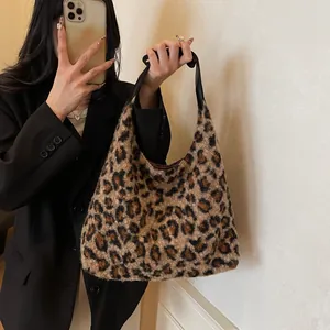 Winterliche Plüschtasche mit Leopardenmuster und Ledergriff am Modell getragen