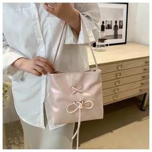 Détail d'un sac à bandoulière crème chic avec nœud décoratif et design à lacets