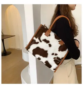 Dettaglio della borsa tote grande con stampa mucca in pelliccia sintetica e manici in pelle