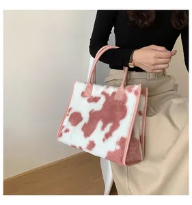 Dettaglio della borsa tote in peluche rosa con stampa mucca e manici rosa rinforzati
