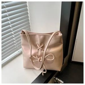 Vue détaillée du sac seau en PU rose avec nœud minimaliste et lanières croisées