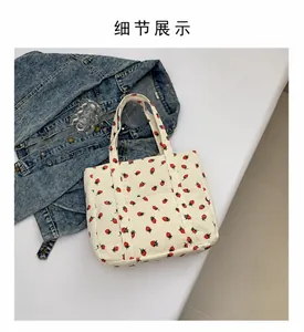 Detailed texture of off-white corduroy tote bag with vibrant red strawberry pattern