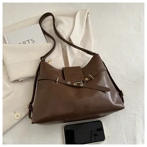 Detail view of dark coffee PU leather shoulder bag with adjustable strap and metal eyelets
