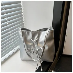 Détail du sac cabas argenté métallisé avec cordon de serrage décoratif et finition en cuir PU
