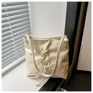 Détail du sac seau blanc cassé avec cordon de serrage à nœud et texture croisée chic