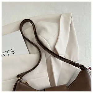 Detailed close-up of stitching and texture on brown leather shoulder bag