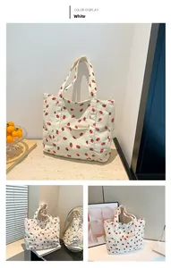 Dettaglio borsa tote in velluto a coste bianco con stampe di fragole e tasca esterna
