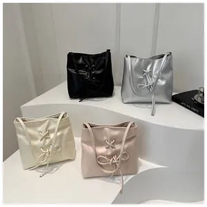 Détail de sacs seaux stylés avec rubans croisés déclinés en quatre couleurs élégantes