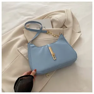 Détail d'un sac hobo en similicuir bleu clair avec fermoir doré et bandoulière chaîne