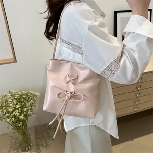 Sac seau rose avec nœud papillon et œillets argentés porté par un mannequin