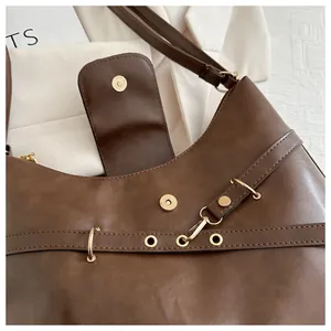 Detail view of brown PU leather shoulder bag with gold magnetic buckle and matte texture