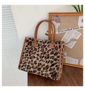 Dettaglio borsa tote leopardata in pelliccia sintetica con manico marrone su base di legno