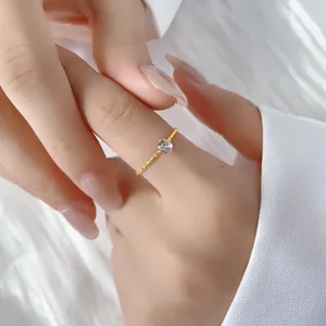 Elegant gold titanium steel ring with sparkling zircon stone on a model's hand