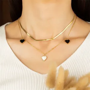Collana doppia dorata con catena a serpente e ciondoli a cuore neri e bianchi