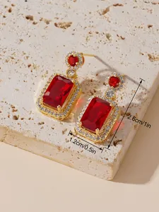 Vue détaillée des boucles d'oreilles vintage avec pierres rouges et halo de diamants blancs