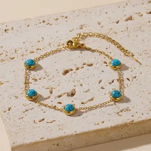 Goldenes Armband mit Türkis-Perlen auf einem natürlichen Steinhintergrund