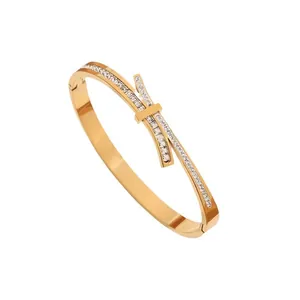 Elegant rose gold titanium bangle with sparkling pavé cubic zirconia bow tie design