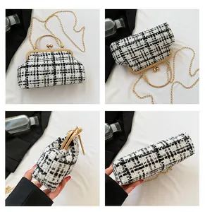 Detailopnames van zwart-witte tweed crossbodytas met gouden handvat en fijne kettingriem