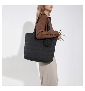 Schicke schwarze gesteppte Shopper-Tasche am Modell mit großem Fassungsvermögen und Stil