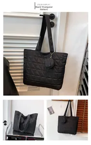 Detail der schwarzen gesteppten Shopper-Tasche mit passendem runden Münzetui-Anhänger