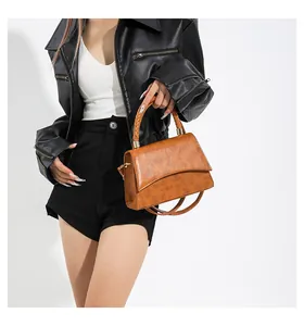 Détail du sac à main marron vintage avec poignée tressée et texture gaufrée