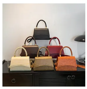 Détail de la poignée tressée et attaches métalliques sur sacs bandoulière trapèze en six tons
