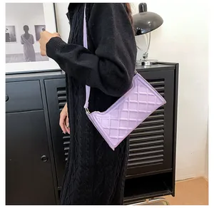 Dettaglio della borsa a spalla lilla trapuntata con motivo a rombi indossata dal modello
