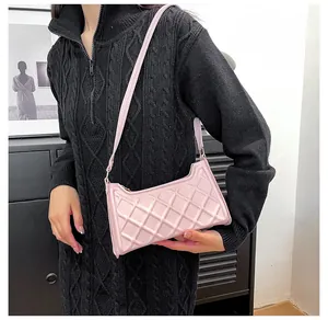 Dettaglio borsa a tracolla rosa trapuntata con cuciture geometriche a rombi su pelle PU