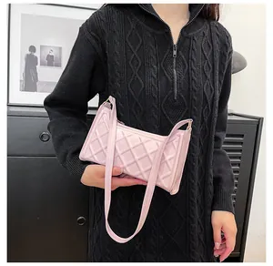Borsa a spalla trapuntata rosa in ecopelle mostrata su modella con maglione nero