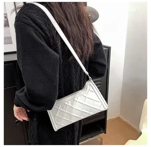 Dettaglio della borsa a tracolla trapuntata bianca con fibbie dorate sulla modella