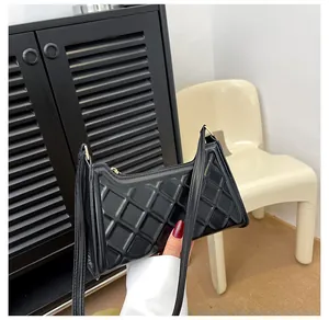 Dettaglio della borsa baguette trapuntata nera in ecopelle lucida con sottile tracolla chic