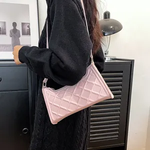 Borsa a tracolla trapuntata rosa dal design minimalista indossata da una modella
