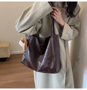 Vista dettagliata della grande borsa tote marrone retrò con ciondolo e texture