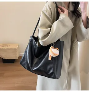 Grande borsa tote vintage nera con ciondolo a forma di orso su una modella elegante