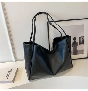 Dettaglio della texture in pelle nera liscia e della finitura della borsa tote grande