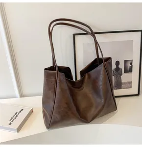 Dettaglio della borsa tote vintage marrone scuro in PU con cuciture laterali