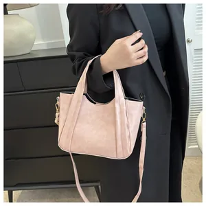 Close-up of pink leather bucket bag with soft texture and golden hardware details