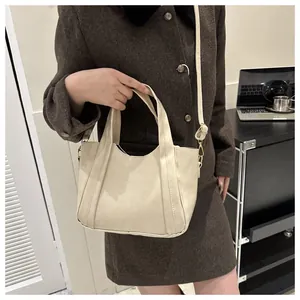 Elegante bolso bombonera de cuero crema con detalles dorados en un entorno de estilo de vida