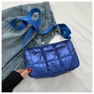 Détail du sac bandoulière matelassé bleu foncé avec finition satinée et sangle réglable